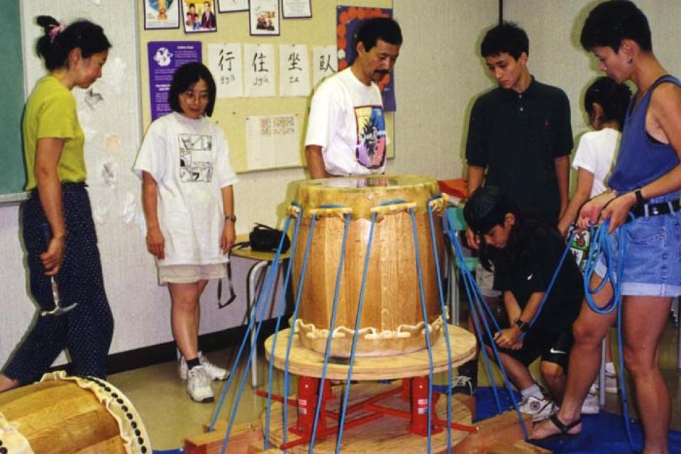 Six people working together to adjust tension of their stretching rig